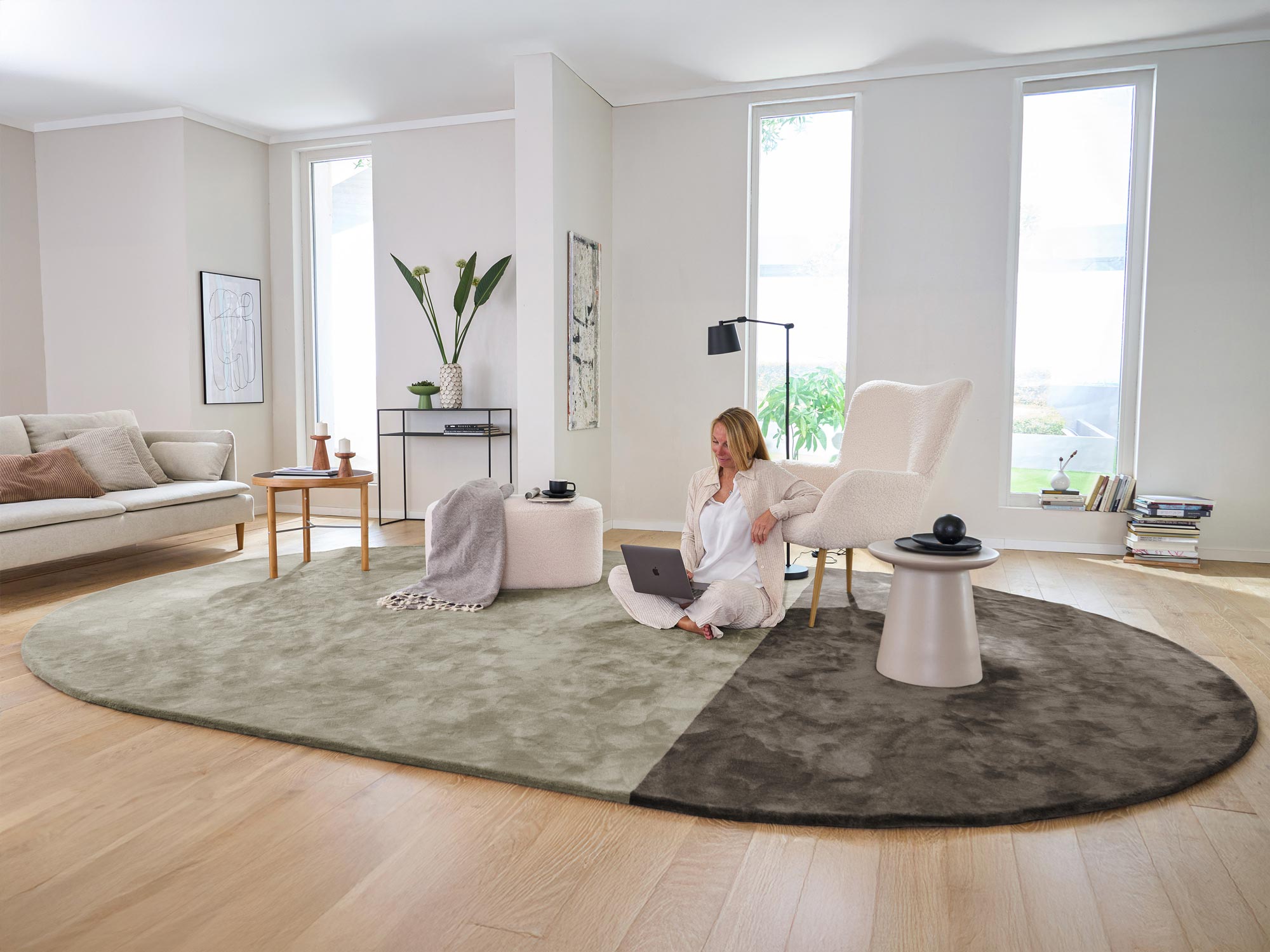 Ovaler zweifarbiger Hochflorteppich Joline von Ruxedo in Braun und Beige in einem hellen Wohnzimmer mit moderner Einrichtung