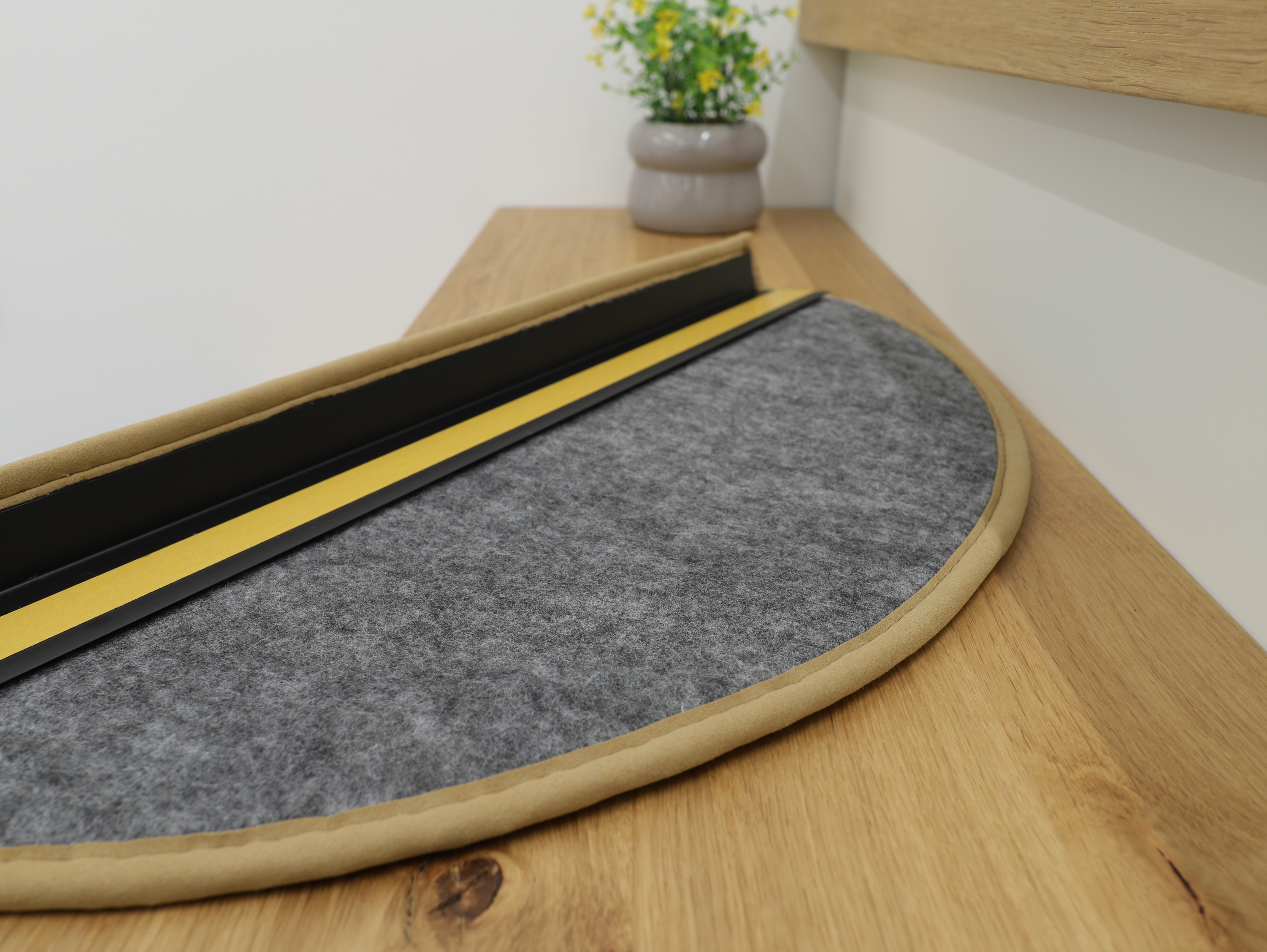 Detailaufnahme einer Ruxedo Stufenmatte mit Komfort-Vliesrücken und integrierter Winkelkante auf Holztreppe