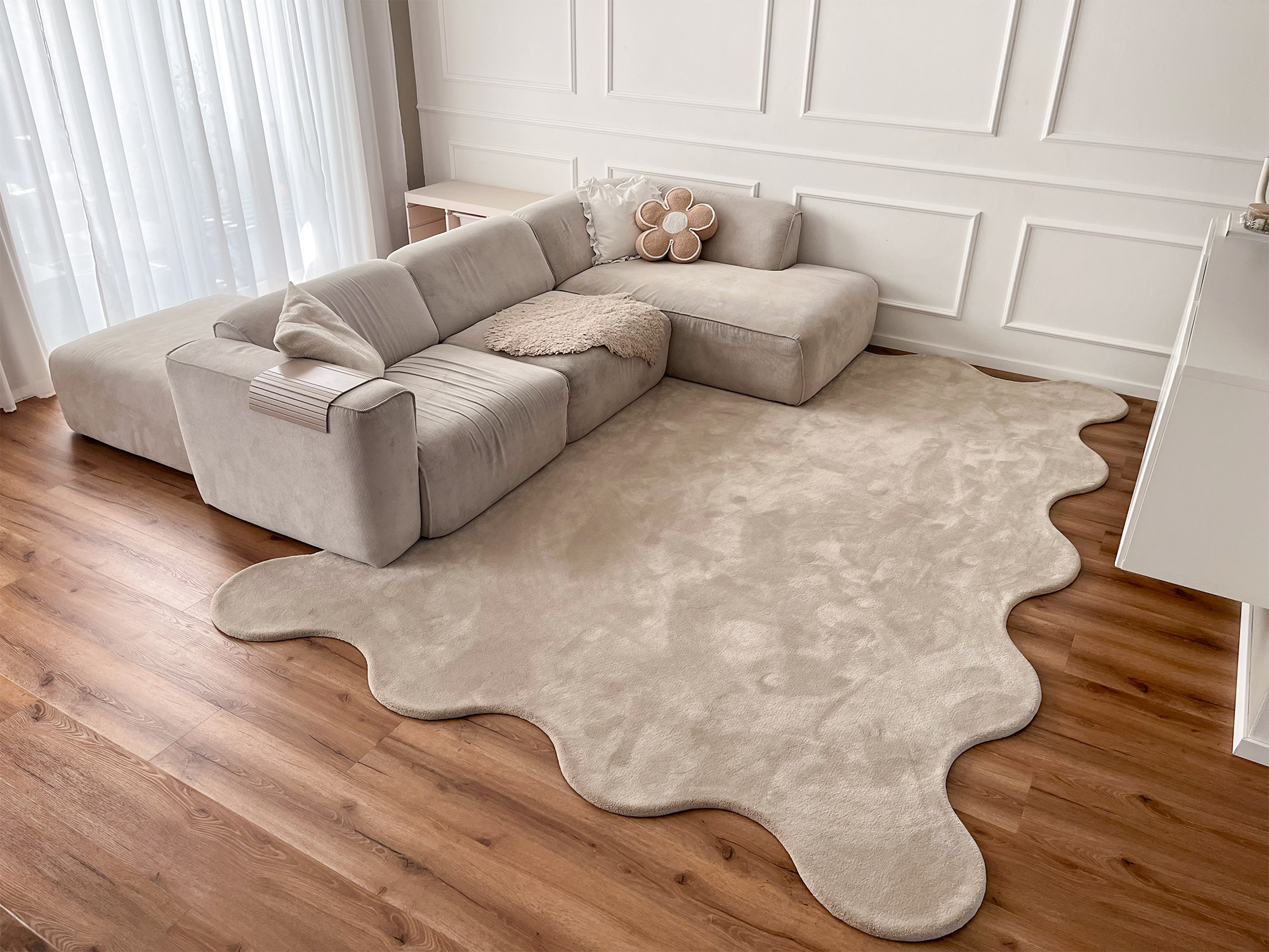 Beiger Hochflorteppich Cecilia von Ruxedo in organischer Sonderform, im modernen Wohnzimmer mit heller Couch und Holzfußboden