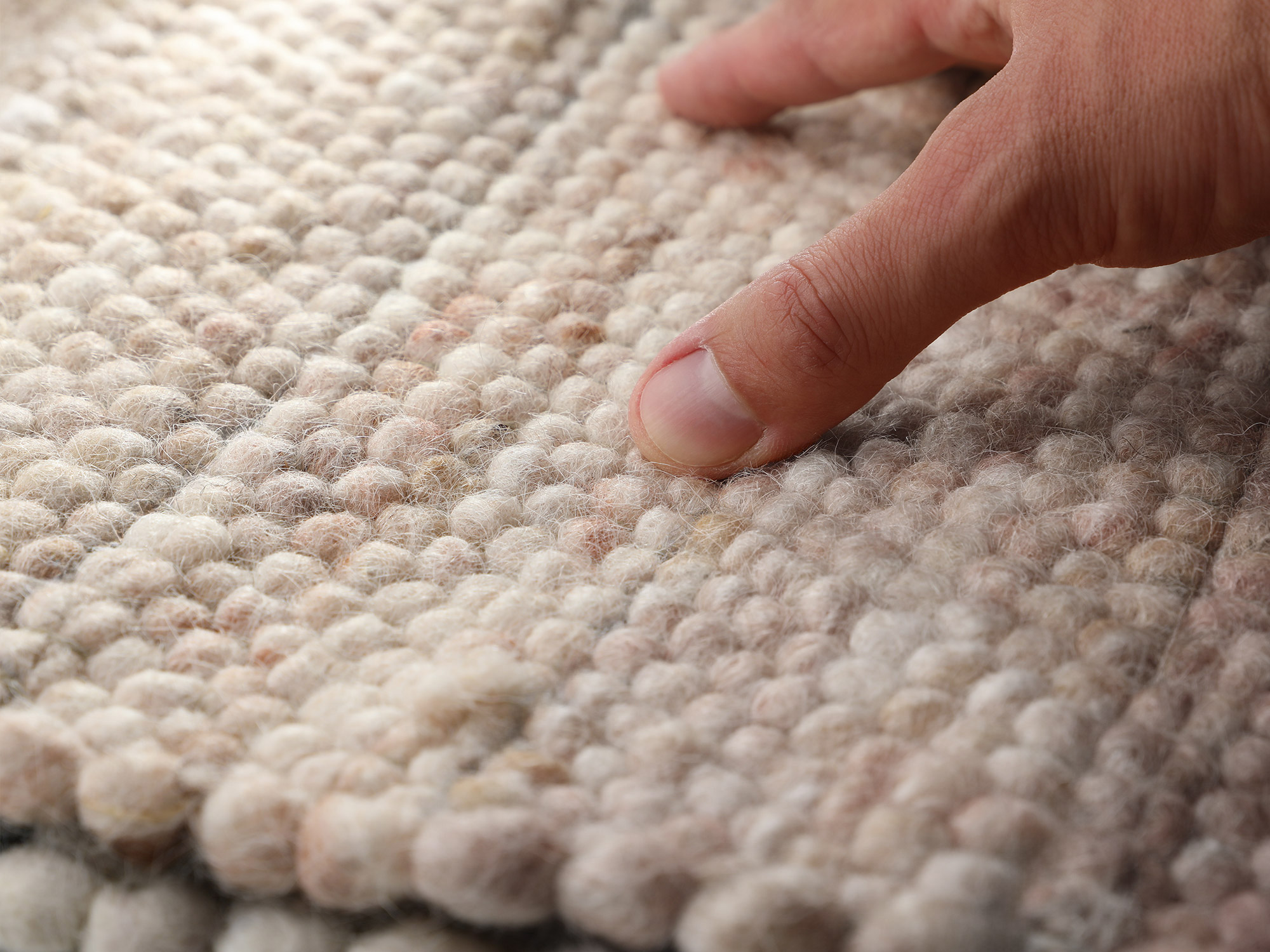 Detailaufnahme eines Ruxedo-Handwebteppichs aus Schurwolle, Nahaufnahme der strukturierten, handgewebten Oberfläche mit sichtbaren Wollschlaufen